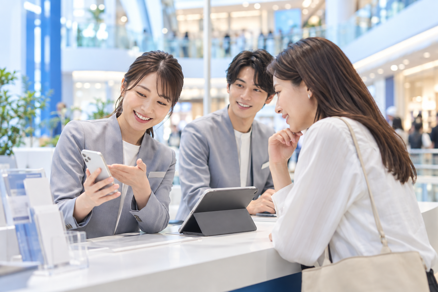 商業施設でお客様に通信サービスを案内するスタッフ